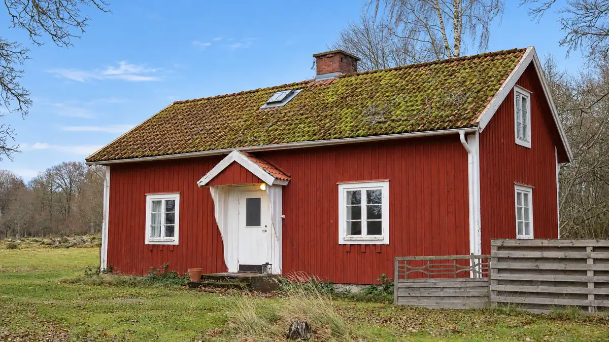 Maison rouge en bois sous un ciel gris d’hiver, et la même maison sous un ciel bleu